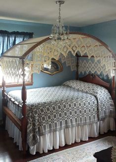 a bedroom with a canopy bed and chandelier hanging from it's ceiling