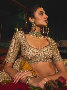 Step into refined elegance with this opulent gold lehenga, a stunning embodiment of artistry and tradition. Crafted from rich raw silk, the lehenga features intricate filigree work that gracefully dances across the fabric like golden vines. Hand-embroidered with vintage gold zari and shimmering sequins, the blouse and lehenga skirt showcase a beautiful romance depicted through floral and bird motifs. Paired with a striking maroon dupatta adorned with a delicate kiran border, this ensemble captures the essence of timeless beauty, making it perfect for any grand occasion. Maroon Dupatta, Raw Silk Embroidery, Gold Lehenga, Anamika Khanna, Diana Penty, Lehenga Skirt, Gold Blouse, Sonakshi Sinha, Tarun Tahiliani