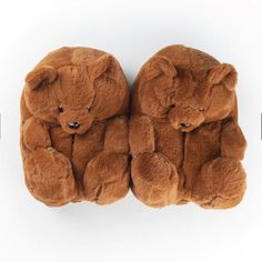 two brown teddy bears sitting next to each other on top of a white surface,