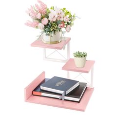 two pink shelves with flowers and books on them