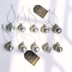 a group of disco ball ornaments with a tag attached to them on a white surface