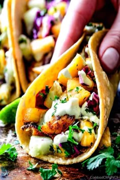 two tacos filled with meat and vegetables on top of a table