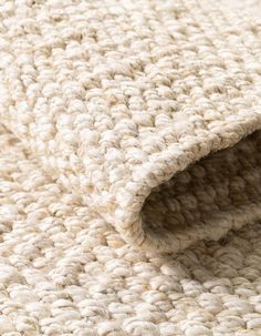 the textured carpet is white and has been made from thick knits, which are soft