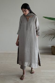 Taupe kurta with woven silver border on sleeve hem, placket and neckline in stripe pattern. Paired with pant.
Components: 2
Pattern: Woven
Type Of Work: Stripe
Neckline: Notched
Sleeve Type: Three quarter
Fabric: Kurta: Handwoven Linen, Pant: Cotton, Lining: Shantoon
Color: Grey
Other Details: 
Side pockets
Attached lining
Note: Dupatta worn by the model is not for sale
Disclaimer: The fabric, color and texture of the final garment might have slight variations from the studio images and we use o Linen Kurti Design, Shorshe Clothing, Linen Suits Women, Studio Images, A Line Kurti, New Kurti Designs, Indian Designer Suits, Simple Kurta Designs, Pakistani Fancy Dresses