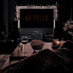 a living room filled with furniture and a large screen tv sitting on top of a wooden table