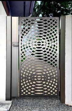 an open metal gate with circular design on it's sides and the door is closed