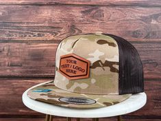 "We proudly launch our hats with genuine leather patch. - PRODUCT DETAILS -----  - Hats are YUPONG 6006 style 5 panel. - The leather patches are crafted from 100% genuine, top-quality leather made in the USA - Adjustable Snapback - One Size Fits All. - 65/35 polyester/cotton - Structured, five-panel, high-profile - Flat bill. - The leather patches on all hats are bonded, not stitched. Our reliable and robust leather bonding technique has been employed for numerous years. - Your logo must be in a black and white JPG format. Ensure that the text and images are in black, while the background should be white. - Explore our diverse range of shapes and fonts! No logo? No worries! We can engrave your custom text using the fonts showcased in our gallery. Additionally, enjoy complimentary custom sh Outdoor Flat Bill Hats With Custom Logo, Brown 5-panel Hat With Logo Patch, Trucker Hat With Leather Patch And Short Brim, Brown Trucker Hat With Logo Patch For Outdoor, Brown Outdoor Hat With Logo Patch, Brown Trucker Hat With Logo Patch And Flat Brim, Brown Trucker Hat With Flat Brim And Logo Patch, Outdoor Short Brim Hats With Logo Patch, Brown Trucker Hat With Custom Logo