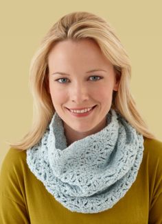 a woman wearing a blue crochet cowl with a smile on her face