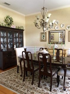 a dinning room table and chairs in front of a china cabinet