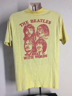 Vintage 70s The Beatles "Away With Words" pocket t-shirt.  Tag does not include fabric information, but feels like 100% cotton, made in USA.  Beatles image is on back.  On front is the logo from KWWL 1330 Waterloo, Iowa.  The station changed their call letters from KWWL in 1980.  "Away With Words" was a film that toured the country in the 70s.Collar is stretched a bit wide.  Otherwise nice condition.  No holes, no stains.Size Large.  Please note measurements to avoid returns: laid flat measures Vintage Cotton Top For Concert, Vintage Concert T-shirt With Text Print, Vintage Pre-shrunk T-shirt For Concert, Vintage Text Print T-shirt For Concert, Vintage Yellow T-shirt With Text Print, Groovy Cotton T-shirt With Letter Print, Groovy Cotton Tops For Streetwear, Film Tshirt, Waterloo Iowa