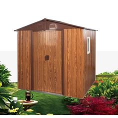 a small wooden shed sitting on top of a lush green field in front of flowers