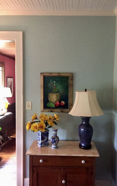 a blue and white vase sitting on top of a wooden table next to a lamp