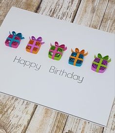 a birthday card with four colorful gift boxes on it and the words happy birthday written in large letters