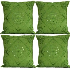 four green pillows with decorative designs on them