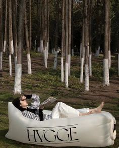 a woman is laying on an inflatable chair with the word hygge printed on it