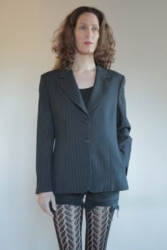 Best of 1990's classic minimalist cool Emporio Armani two button blazer. Great androgynous masculine style. Pin stripes on black background with white and grey stripes. Side front pockets. Fully lined. Slight shoulder pads give good shape to the shoulders. Label Emporio Armani, Made in Italy, Size 46. Dry clean only. 61% rayon, 30% pure wool, 5% nylon, 3% cotton, 1% polyester. Lining 100% rayon. Very good vintage condition with no fabric or sewing flaws. MeasurementsShoulders 44cm/ Chest 102cm/ Striped Single-breasted Blazer For Office, Classic Pinstripe Blazer For Office Wear, Classic Striped Blazer For Office, Pinstripe Single Breasted Blazer For Office Wear, Pinstripe Long Sleeve Blazer For Office, Office Blazer With Vertical Stripes And Long Sleeves, Classic Single-button Striped Blazer, Classic Striped Outerwear For Office Wear, Classic Long Sleeve Blazer With Vertical Stripes