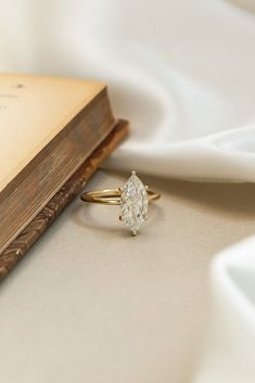 a close up of a book with a ring on it and a piece of cloth in the background