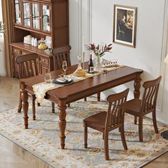 a dining room table set with chairs and a china cabinet in the corner, along with a rug on the floor