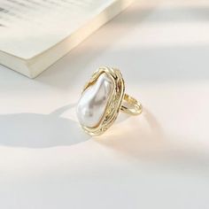 Vintage Irregular Pearl Rings Step into a world of timeless elegance with our Vintage Irregular Pearl Rings. Each ring is a unique piece of art, designed to showcase the beauty of nature and the sophistication of vintage style. Unique Features: Irregular Pearl Design: Each ring features a stunning irregular pearl, ensuring that no two pieces are alike, celebrating individuality and authenticity. Vintage Appeal: Crafted with a nod to classic styles, these rings blend seamlessly with both modern a Elegant Metal Pearl Open Ring, Elegant Open Metal Pearl Ring, Elegant White Crystal Metal Ring, Gold Pearl Open Ring, Elegant Open Ring Made Of Metal, Gold Open Pearl Ring, Elegant Pearl Open Ring In Metal, Elegant Open Ring Jewelry With Unique Design, Elegant Open Ring In Metal