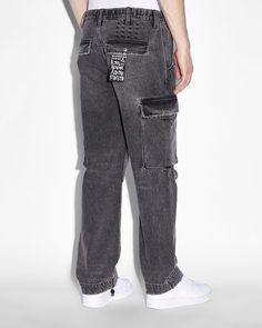 The Riot Cargo Pant Angst Black is a mid rise, relaxed pant with a fixed waistband and shank button fly front. These cargo pants feature elastic hems with t-cube toggle fasteners and are crafted from a rigid 11oz black denim with aging treatments. Details include diagonal cutaway pockets, frontward facing cargo pockets, and back press studded welt pockets. Finished with tonal front cross dollar, t-box and 4x4 embroidery. Relax Pants, Shank Button, Cargo Pant, Press Studs, Denim Pant, Welt Pockets, Welt Pocket, Black Denim, Cargo Pants