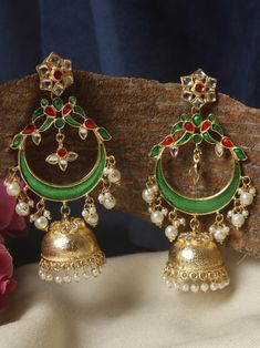 These  green and golden  long jhumkas are an exquisite accessory that exudes elegance and sophistication. Crafted with meticulous attention to detail, these earrings feature a mesmerizing combination of green and golden, creating a stunning contrast that catches the eye. The dark green pearls possess a deep, rich hue reminiscent of lush forests, adding a touch of intrigue and mystery to the overall design.  These earrings boast a long and slender design, gracefully cascading from the earlobes to create an alluring effect. The length adds a sense of drama and sophistication, making them perfect for formal occasions or adding a touch of elegance to everyday outfits. Whether you're attending a gala, a wedding, or a cocktail party, these long jhumkas are  sure to turn heads and elevate your st Festive Green Kundan Traditional Wear, Peacock Design Jhumkas For Party And Festivals, Festival Peacock Design Jhumkas For Parties, Bollywood Style Peacock Chandbalis For Festive Occasions, Party Peacock Design Jhumkas For Festivals, Diwali Green Traditional Wear With Latkans, Festive Peacock Design Chandbalis For Festivals, Festive Peacock Design Chandbalis, Green Traditional Wear With Latkans For Diwali