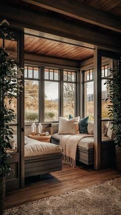 a living room filled with lots of windows next to a couch and coffee table on top of a wooden floor