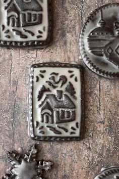 some cookies are sitting on top of a wooden table and decorated with frosted decorations