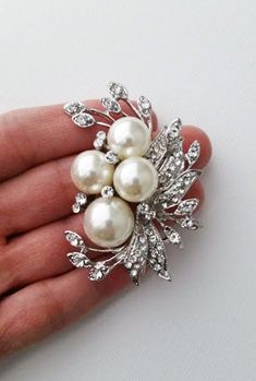 A pearl brooch is a decorative piece that accents and forms the shape of a neckline. A Pearl brooch is also known as a corsage pin. This brooch is a perfect accessory for the fall season. It features a large pearl and leaves with a rhinestones accent. It's the ideal way to add elegance and style to your everyday wear. ⭐   6 cm x 5m that is about 2.4" x 2" ⭐   Lead, cadmium, and nickel free ⭐   Pearl sizes are 14mm and 10mm ⭐   Pearl color is a soft ivory ⭐   Seriously unique for more brooches & pins https://www.etsy.com/shop/okqSupply?ref=seller-platform-mcnav§ion_id=27262035 Bridal Rhinestone Headpiece, Brooch Bouquet Diy, Brooch Corsage, Bridal Brooch Bouquet, Rhinestone Headpiece, Wedding Brooch Bouquets, Corsage Pins, Bridal Accessories Jewelry, Brooch Diy