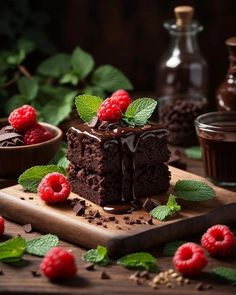 a piece of chocolate cake with raspberries and mint leaves on a cutting board