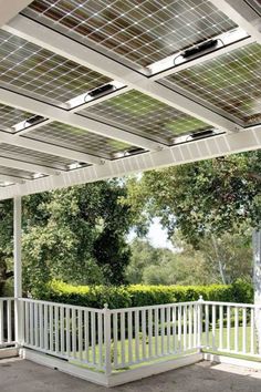 a white porch with solar panels on the ceiling and some trees in the back ground