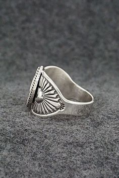 This finely crafted sterling silver ring was made by Navajo silversmith Derrick Gordon. The back is signed Derrick and stamped sterling.Size: 9.5Length: 5/8"Free shipping on all orders! We ship with USPS and always include tracking. All orders ship within a day of payment.Returns are accepted up to 30 days after you receive your order. Just send us a message. Our shop offers cash back or store credit. The item must be returned in new condition. Sterling Silver Turquoise Ring With Concho, Silver Southwestern Style Rings, Southwestern Style Untreated Silver Rings, Silver Concho Rings Perfect For Gifts, Artisan Silver Ring With Concho, Silver Concho Rings For Gift, Western Sterling Silver Concho Rings, Silver Turquoise Concho Ring In Sterling Silver, Unique Silver Ring With Concho Detail