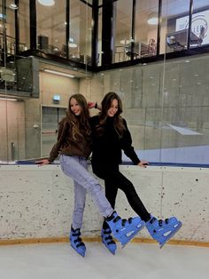 two girls are skating on an ice rink