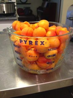 a glass bowl filled with oranges sitting on top of a counter