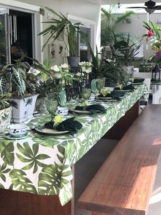 the table is set with green plates and plants