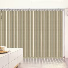 the blinds in this room are made out of beige and white striped fabric, with vertical rods