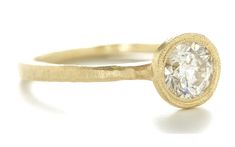 a yellow gold ring with a diamond in the center