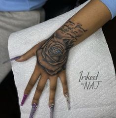 a woman's hand with a rose tattooed on the middle of her left arm