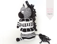 a black and white striped stuffed animal with tassels on it's back