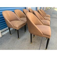 six tan leather chairs lined up against a blue wall