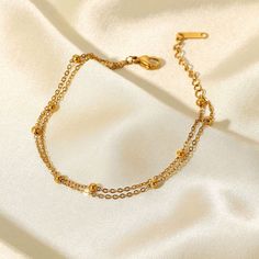 The Gemma Double Satellite Bracelet is a great layering piece, it is dainty but still makes a statement! With a youthful and contemporary feel, this adorable bracelet is a must-have for your stacking bracelet collection. Chain Length: 6 3/4" with a 1 1/4" extender 18K Gold Plated Stainless Steel Double Satellite Chain Water and Tarnish Resistant: Crafted to withstand everyday wear and tear Hypoallergenic: Made with high-quality materials and is safe for those with sensitive skin. Electroplating Jewelry, Double Chain Bracelet, Everyday Wear Jewelry, Layered Bracelet, Titanium Bracelet, Bracelet Dainty, Gold Bead Bracelets, Layered Chains, Minimalist Bracelet