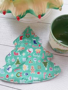 a green christmas tree pot holder next to a bowl