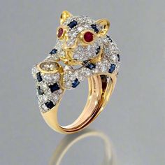 Discover the exquisite beauty of our Panther Diamond Sapphire and Ruby 18K Yellow Gold Ring. This vintage piece is even more stunning in person, showcasing a harmonious combination of diamonds, sapphires, and rubies. Expertly crafted with 18K yellow gold, this ring is a timeless addition to your jewelry collection. Jewelry Style : Ring Signed : Rothschild's Metal Type : 18K Gold  Diamonds : 1 Champagne round diamond : approximately .42 carat, additional 1.98 ctw in round brilliant diamonds, SI1 clarity, G-H color Sapphire :2.06 ctw Ruby : .15 ctw Total Weight : Approximately 12.88 grams  Ring Size : 6 :  Can be sized by your local jeweler, Has a sizing spring to ensure ring sits upright on finger estate piece, sold as is, all weights are estimates