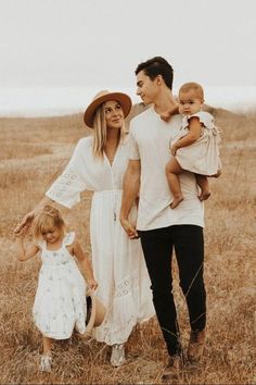 a man, woman and child standing in a field