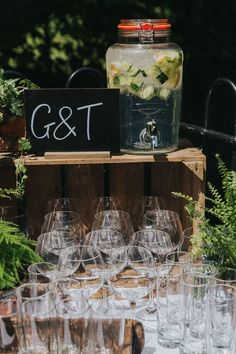 wine glasses are lined up in front of a sign that says g & t on it