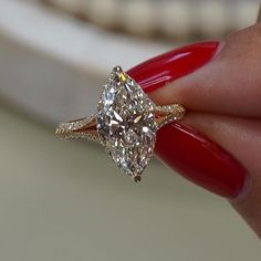 a close up of a person holding a ring with a diamond on it's side