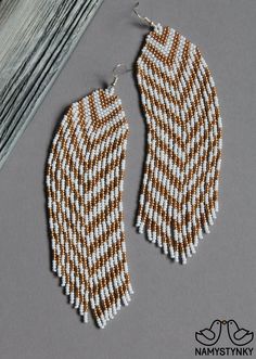 two pairs of beaded earrings sitting next to each other on a gray surface,