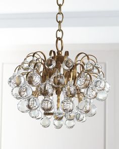 a chandelier hanging from the ceiling in a room with white walls and doors