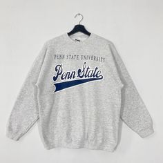 Vintage Pennsylvania State University Sweatshirt Pennsylvania Crewneck Pennsylvania Sweater Penn State Nittany Lions Print Logo Grey Large 𝐁𝐫𝐚𝐧𝐝 :- Pennsylvania State University  𝐒𝐢𝐳𝐞 𝐓𝐚𝐠 :- Large Manual Measurement :- 𝐖𝐈𝐃𝐓𝐇 (armpit to armpit) :- 23 inches / 58cm 𝐋𝐄𝐍𝐆𝐓𝐇 (shoulder to end of garment) :- 27 inches / 69cm 𝐂𝐨𝐧𝐝𝐢𝐭𝐢𝐨𝐧 :- Good Condition 8/10.                      - No Hole, No Stain. - Colors Might Be Different Due To Lighting. - All items are VINTAGE whi Vintage Gray Tops For College, Collegiate Winter Tops With Text Print, Vintage Long Sleeve Tops With Lettering, Vintage Gray Tops With Ribbed Cuffs, Varsity Style Winter Top With Lettering, Varsity Style Top With Lettering, Winter College Tops With Lettering, Lettering Tops For College In Winter, Pennsylvania State University