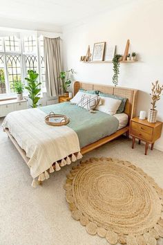 a bedroom with a bed, nightstands and potted plants