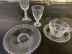 three glass dishes and two cups on a table